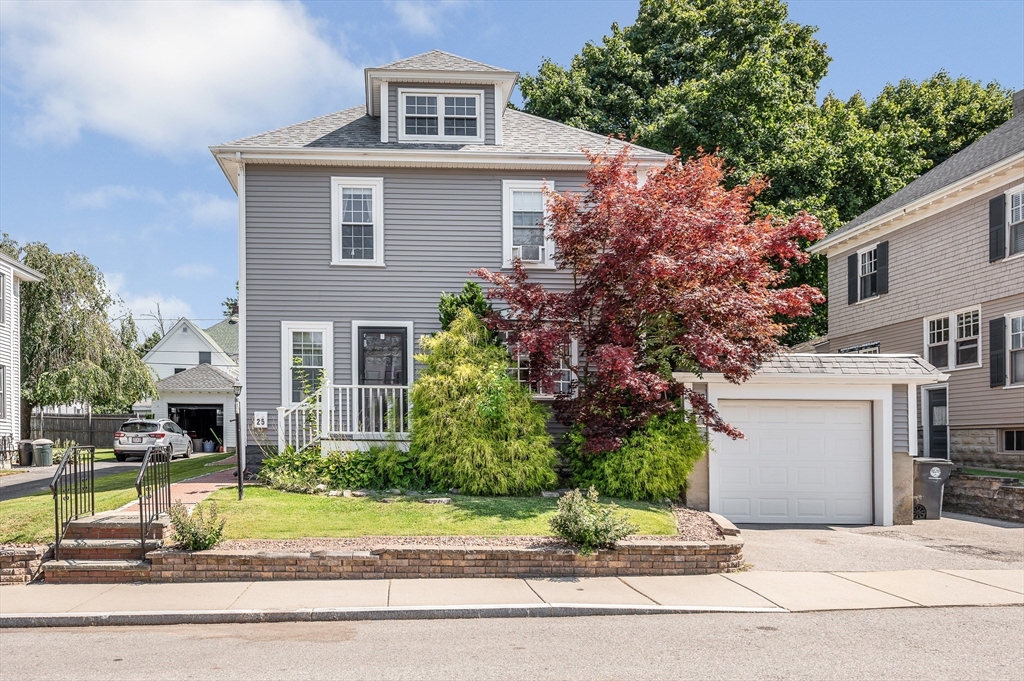 a front view of a house with a yard and tree s