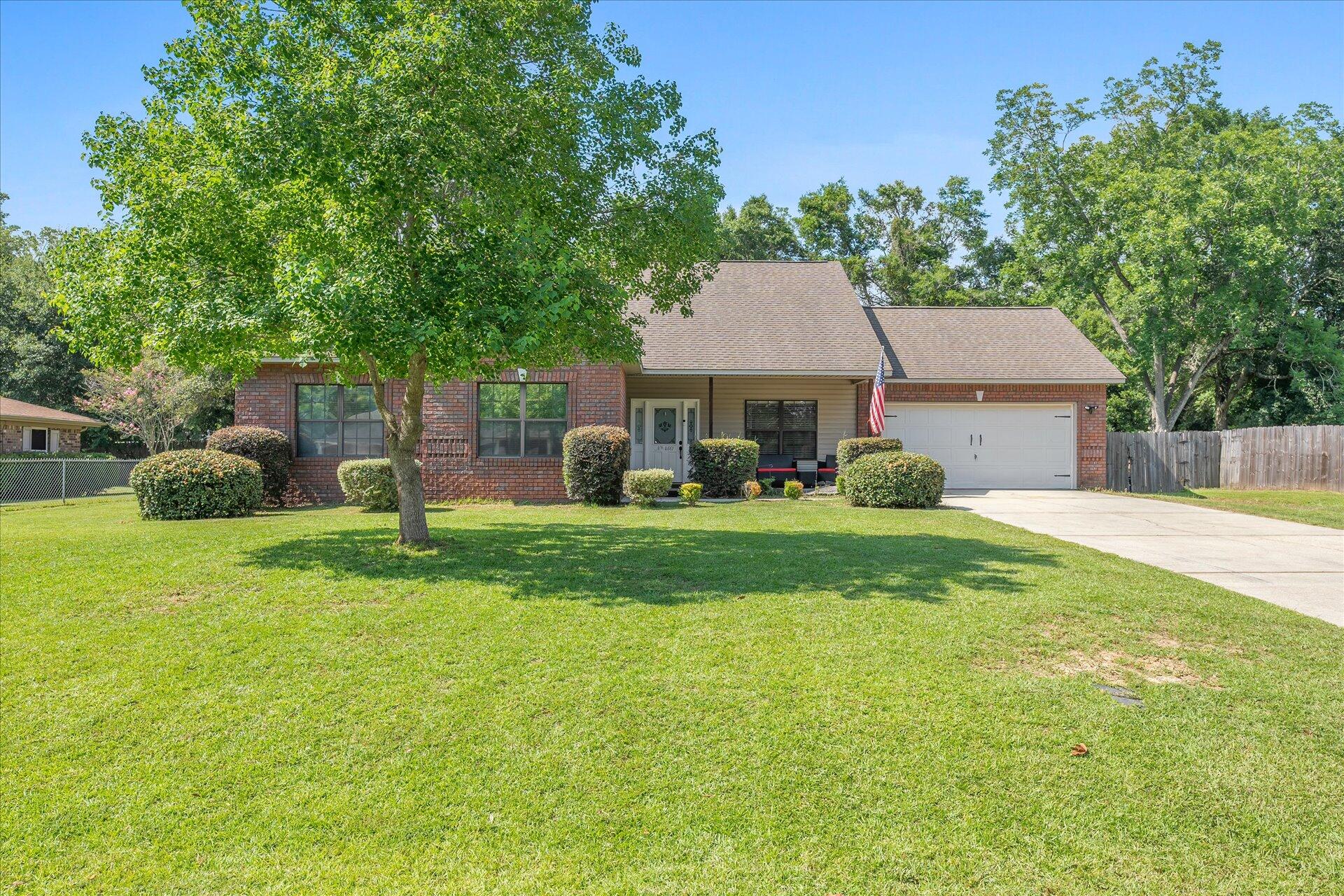 a front view of a house with a yard and trees