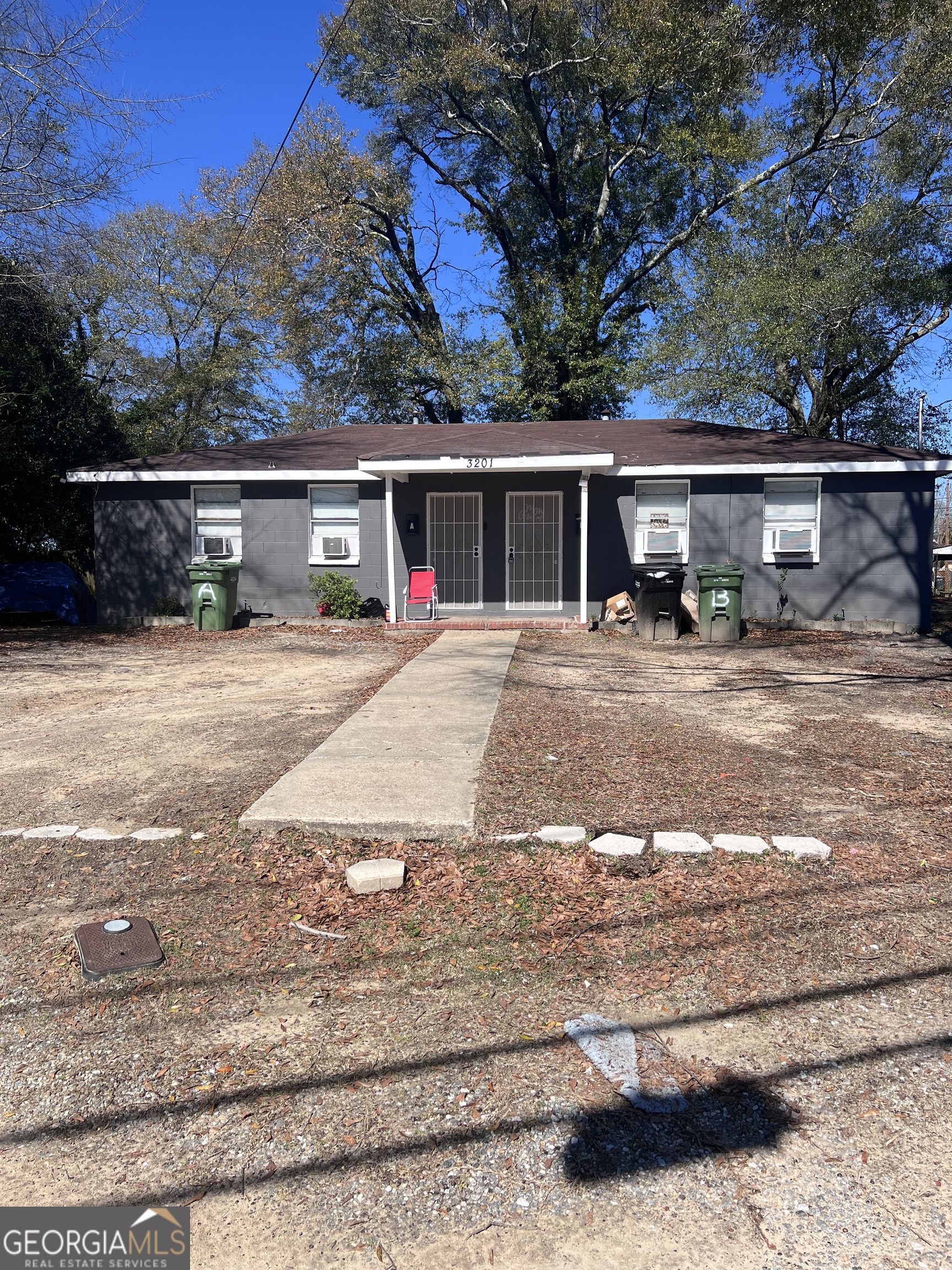 a front view of house with yard outdoor seating and covered with trees