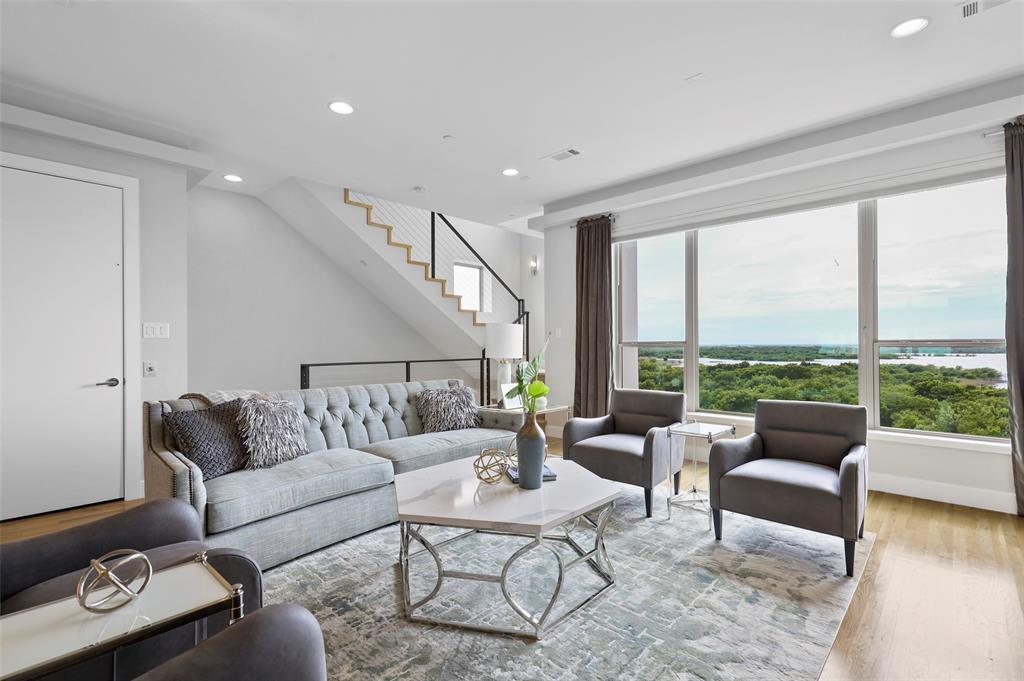 a living room with furniture and floor to ceiling windows