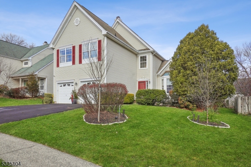 a front view of a house with a garden and yard