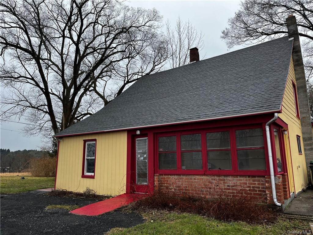 a view of a house with backyard and trees