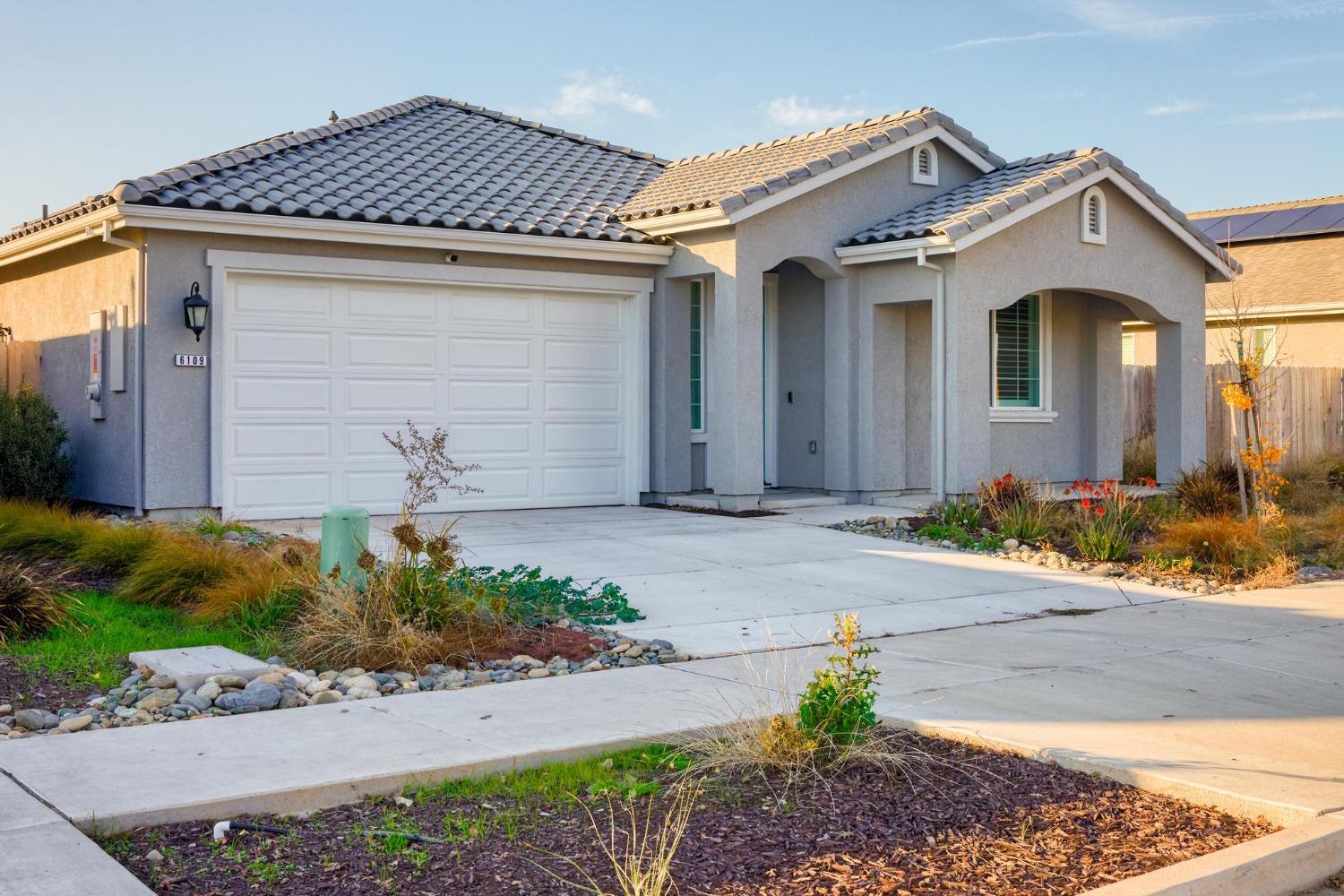 a front view of a house with a yard and a garage