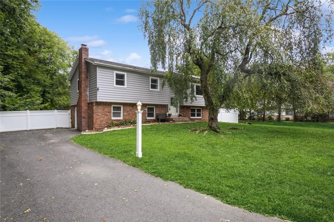 a front view of a house with a yard and trees