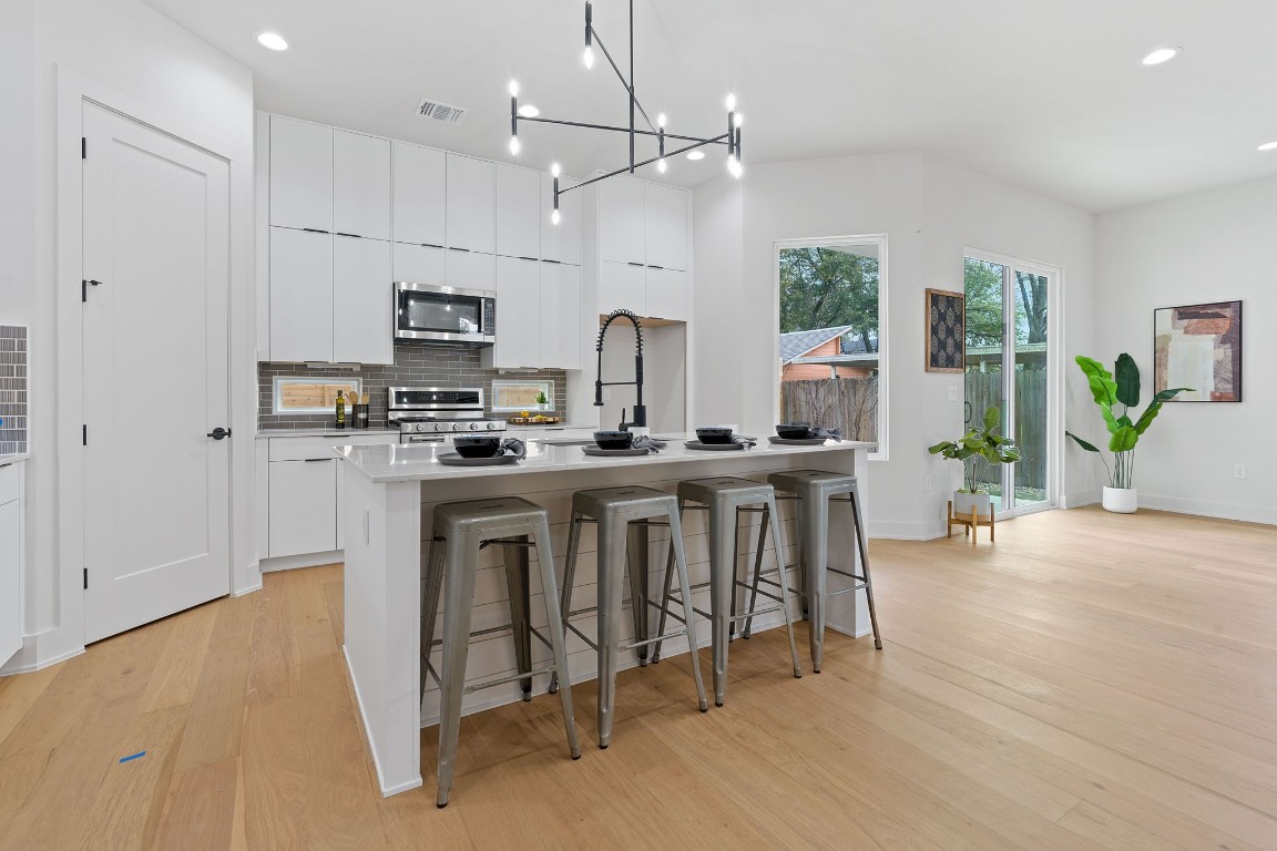 a kitchen with white cabinets and stainless steel appliances