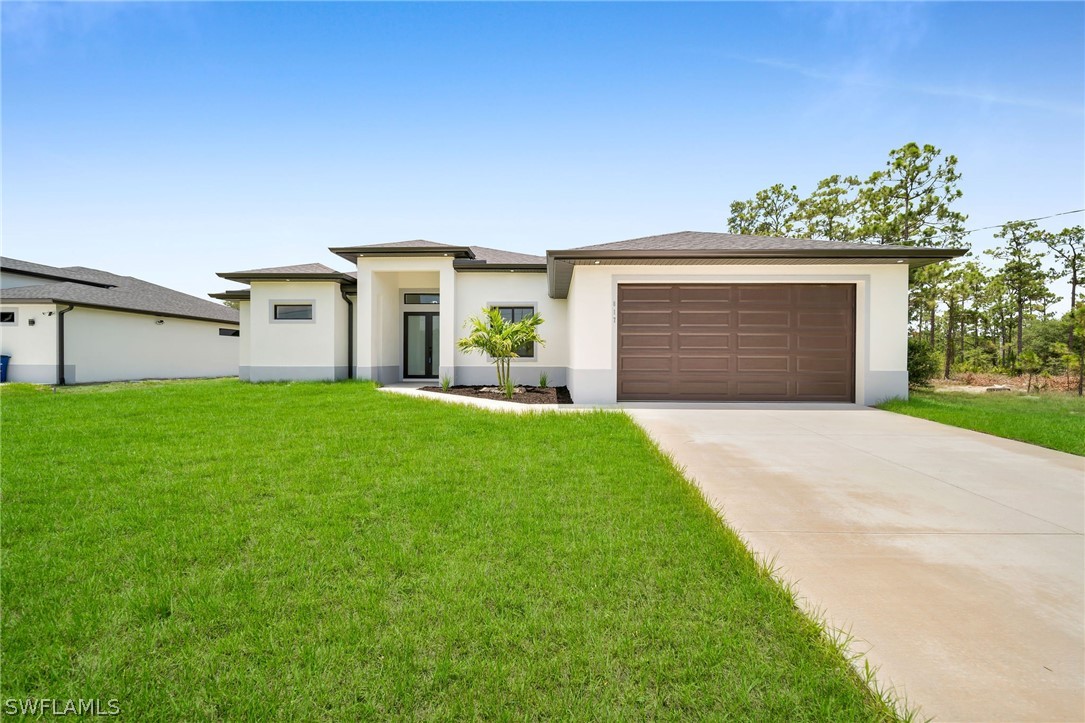 a front view of house with yard and garage