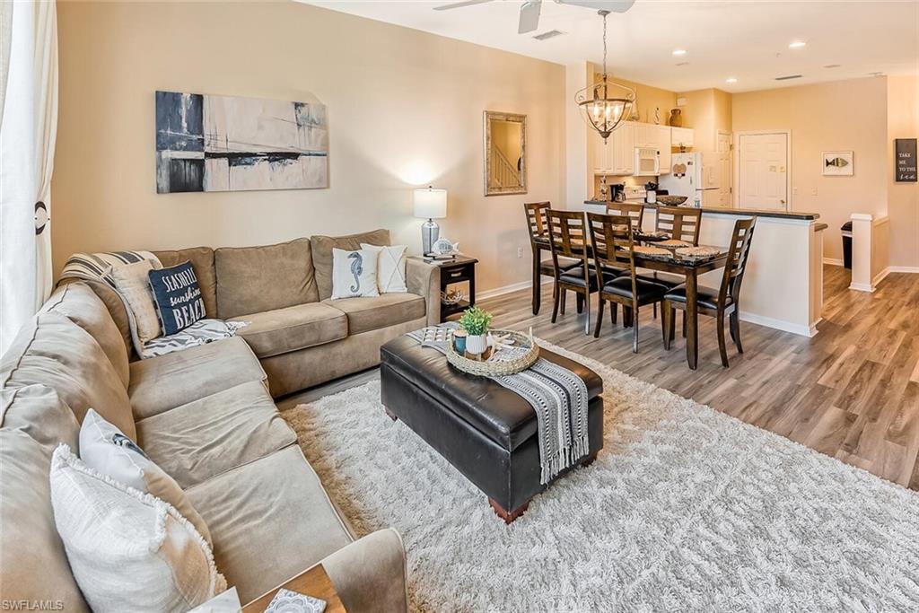 a living room with furniture wooden floor and a chandelier