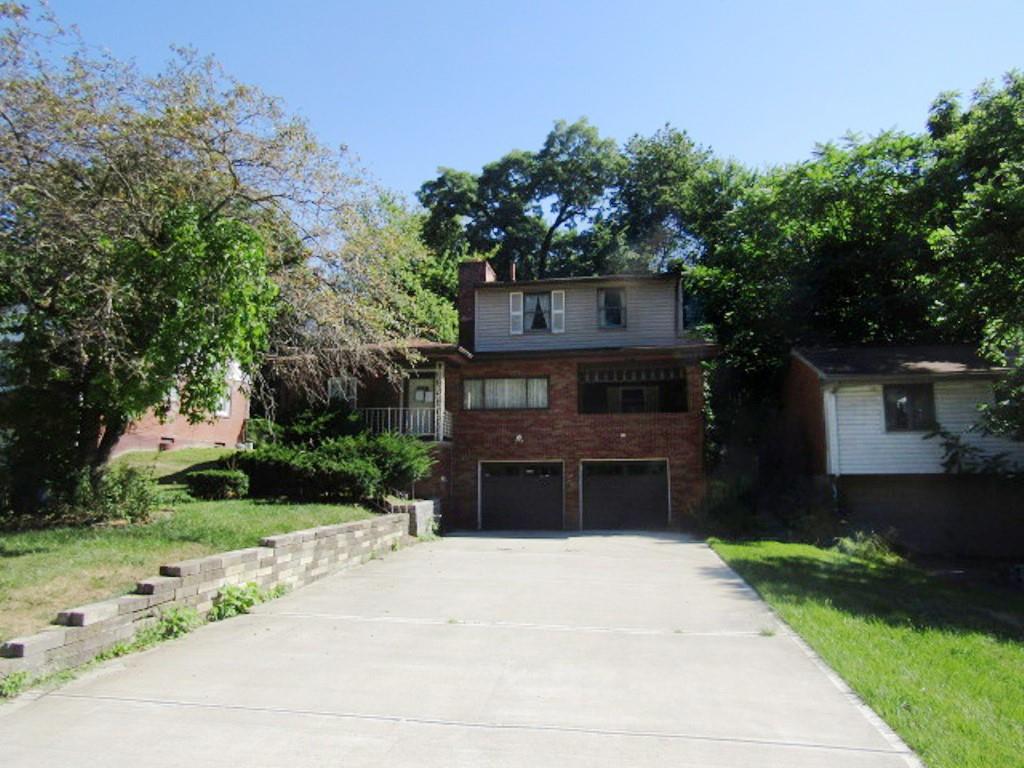 a front view of a house with a yard and a garage