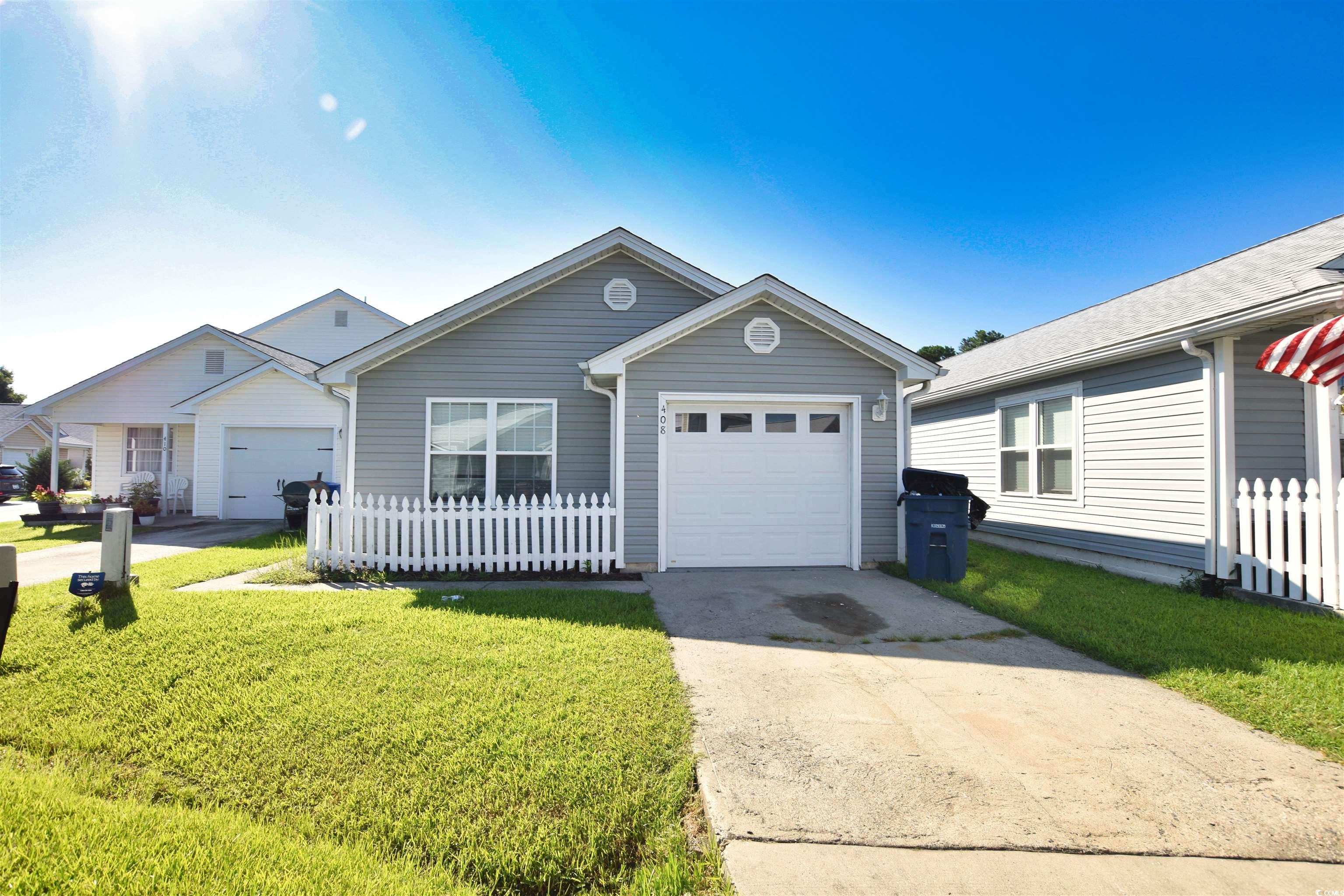 Ranch-style house with a garage and a front lawn