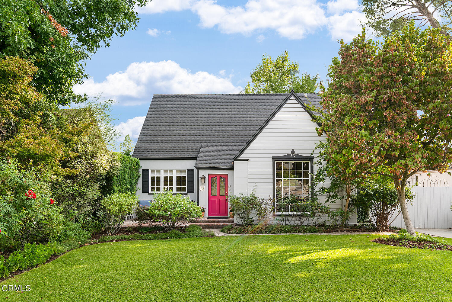 a front view of a house with a yard and trees