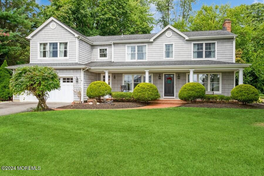 a front view of a house with a yard and trees