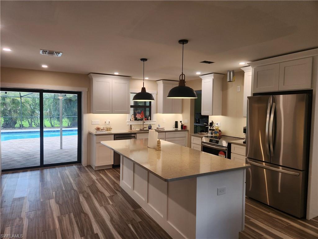 a kitchen with counter top space a sink appliances and cabinets