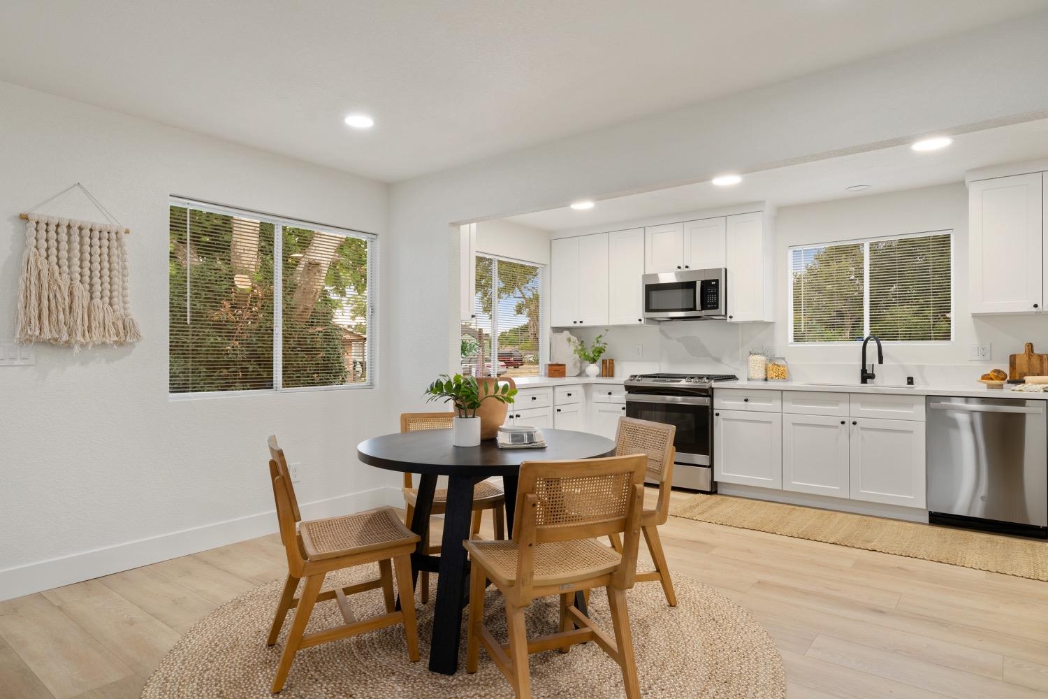 a kitchen with a table chairs sink and cabinets