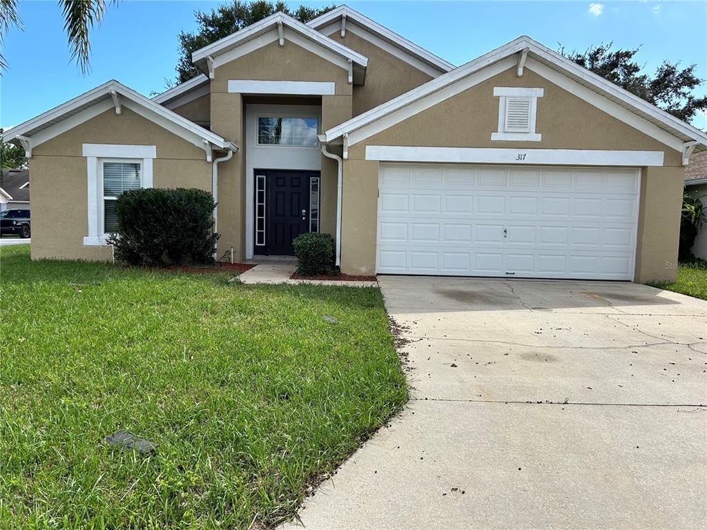 a front view of a house with a yard and garage