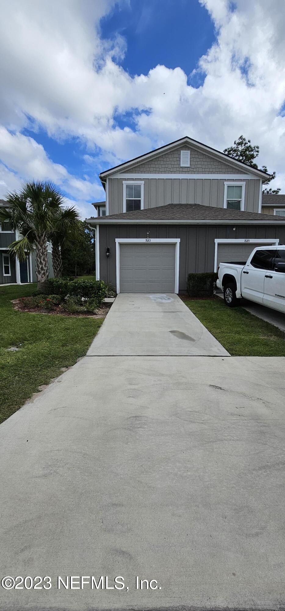 a front view of a house with a garden and yard