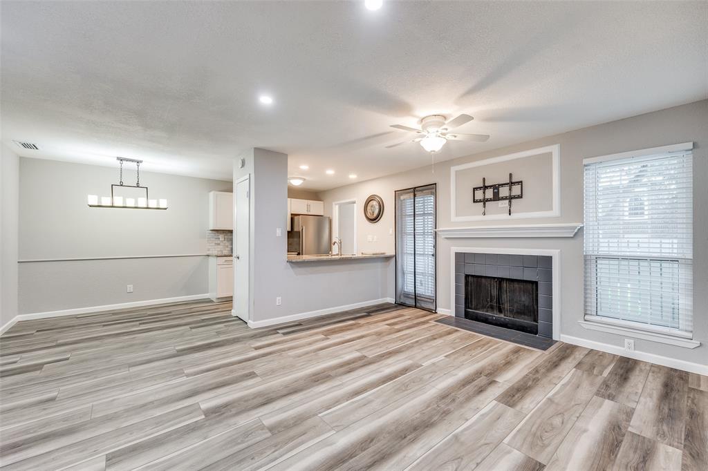 a view of empty room with fireplace and wooden floor