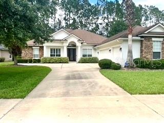 a front view of a house with a yard and trees