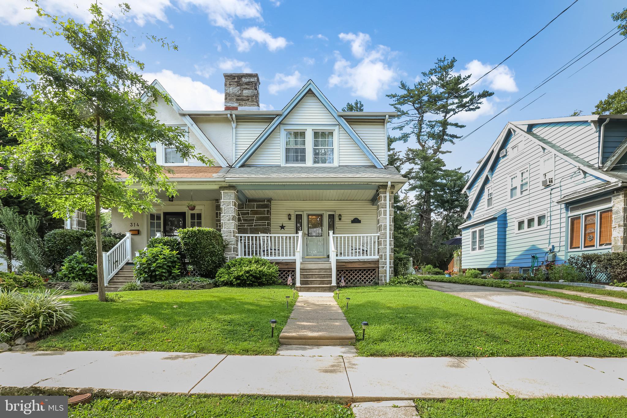 a front view of a house with a yard and potted plants