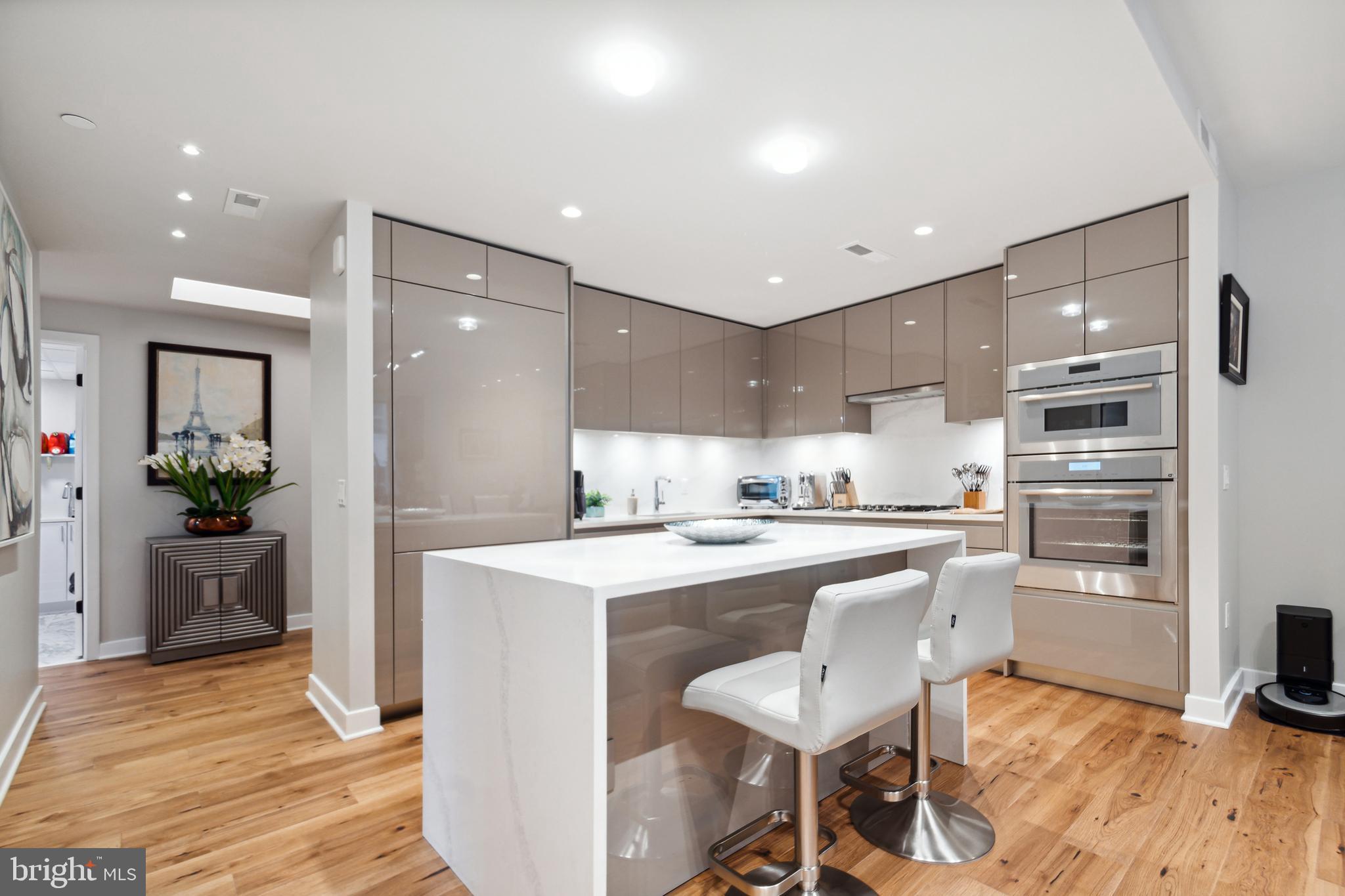 a kitchen with a sink stainless steel appliances and white cabinets