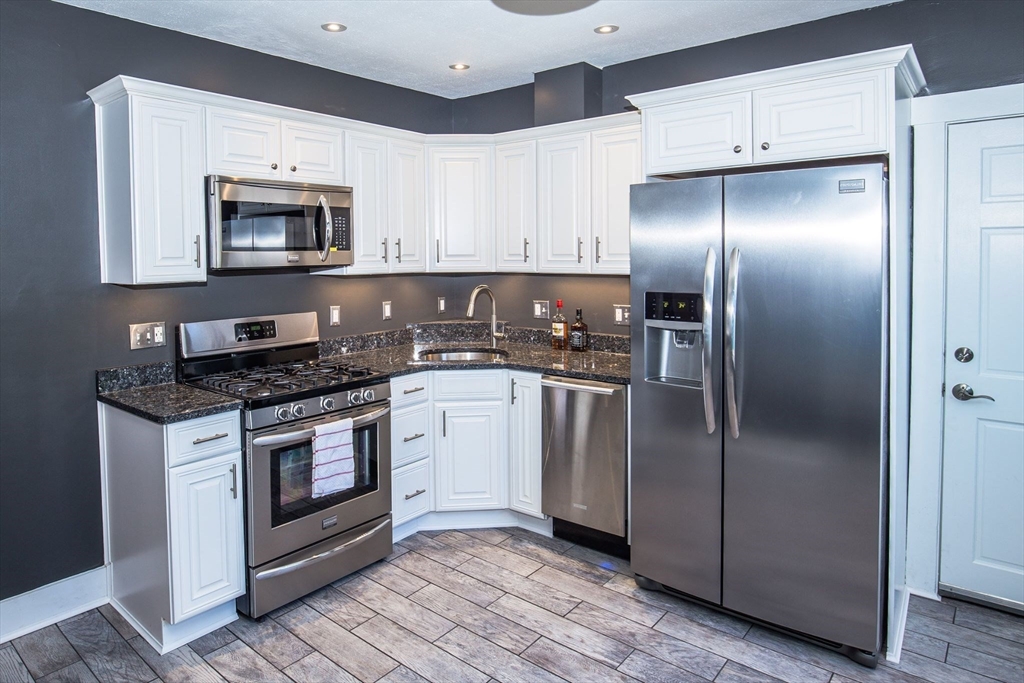 a kitchen with a refrigerator sink and cabinets