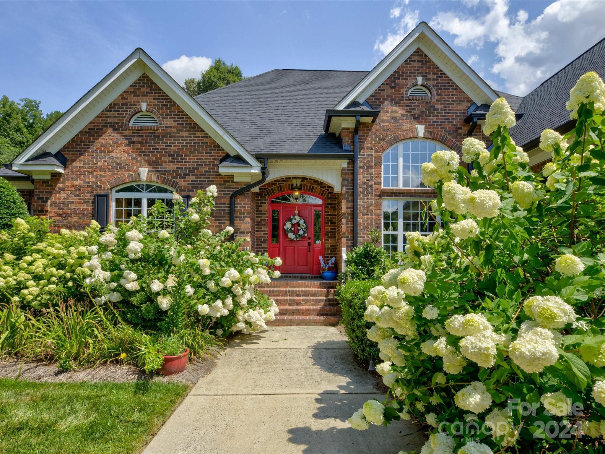 a front view of a house with a yard and flowers