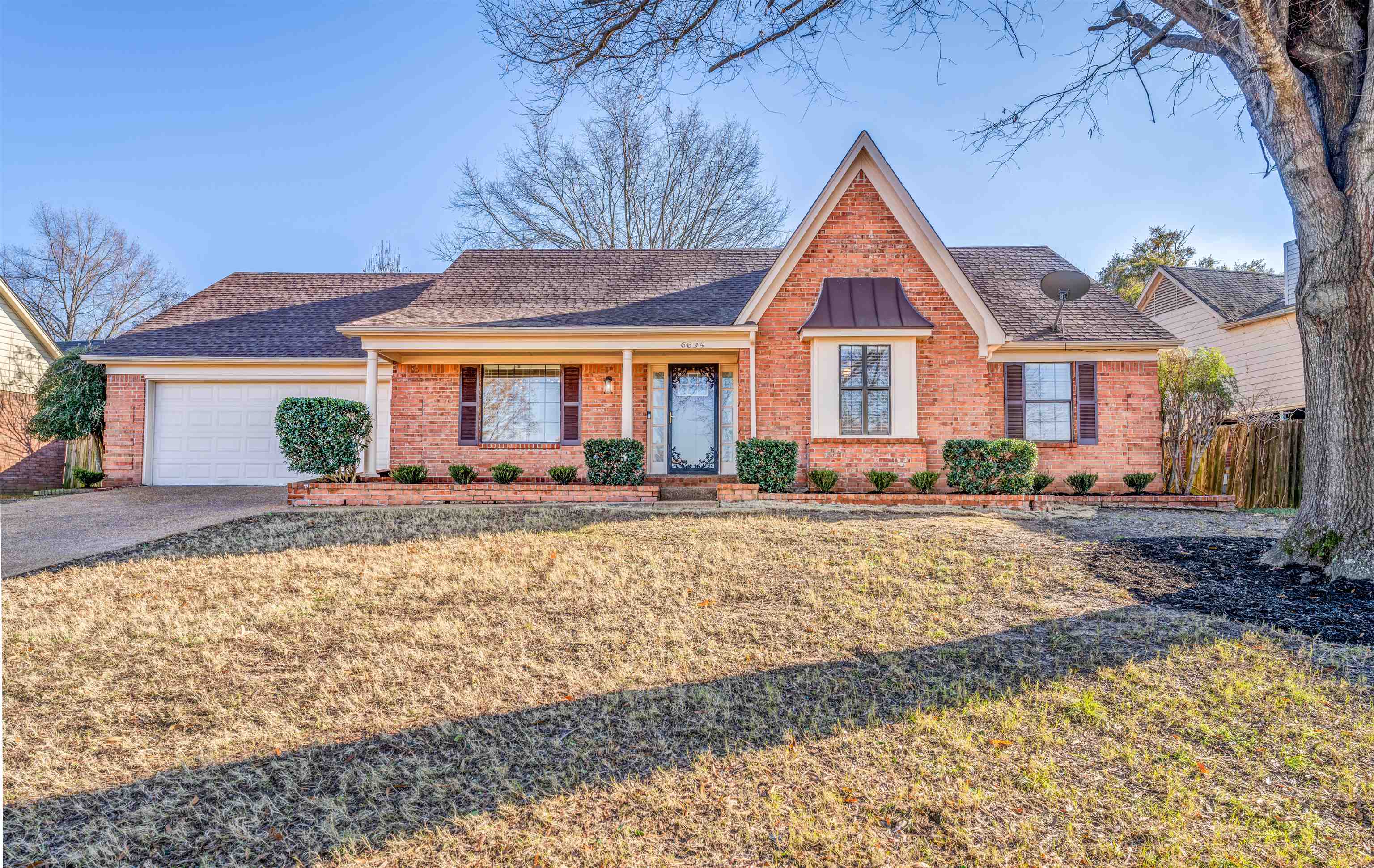 Ranch-style house featuring a front lawn and a garage