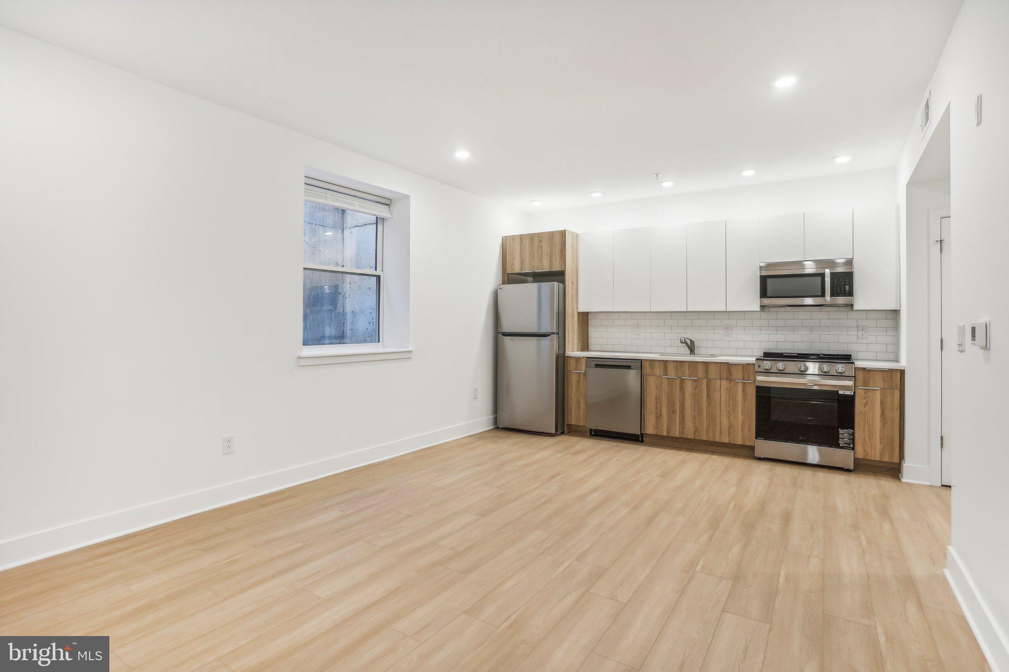 a kitchen with stainless steel appliances a refrigerator and a stove top oven