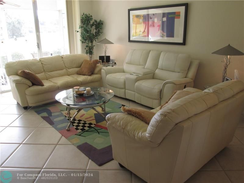 a living room with furniture a rug and a window