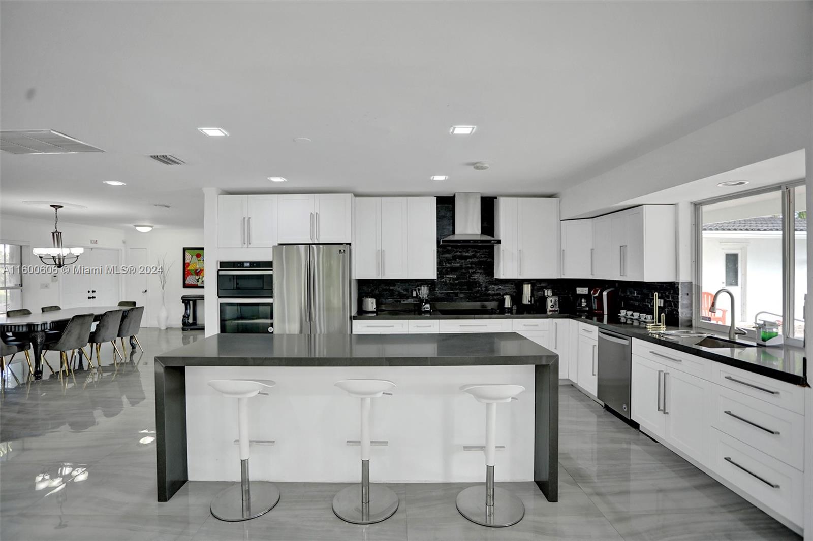 a large kitchen with a large counter top stainless steel appliances and cabinets