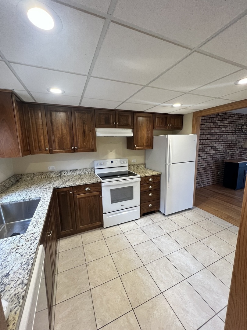 a kitchen with granite countertop a sink a counter space and stainless steel appliances