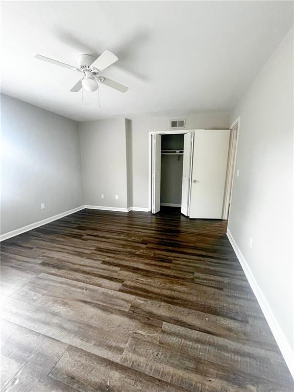 a view of an empty room with wooden floor and cabinet