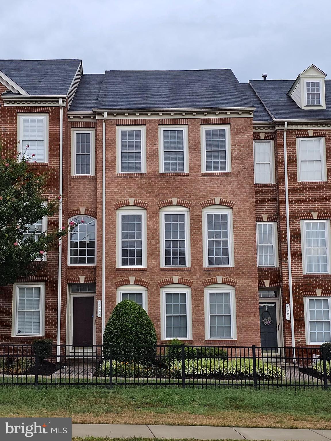 a front view of a residential apartment building with a yard