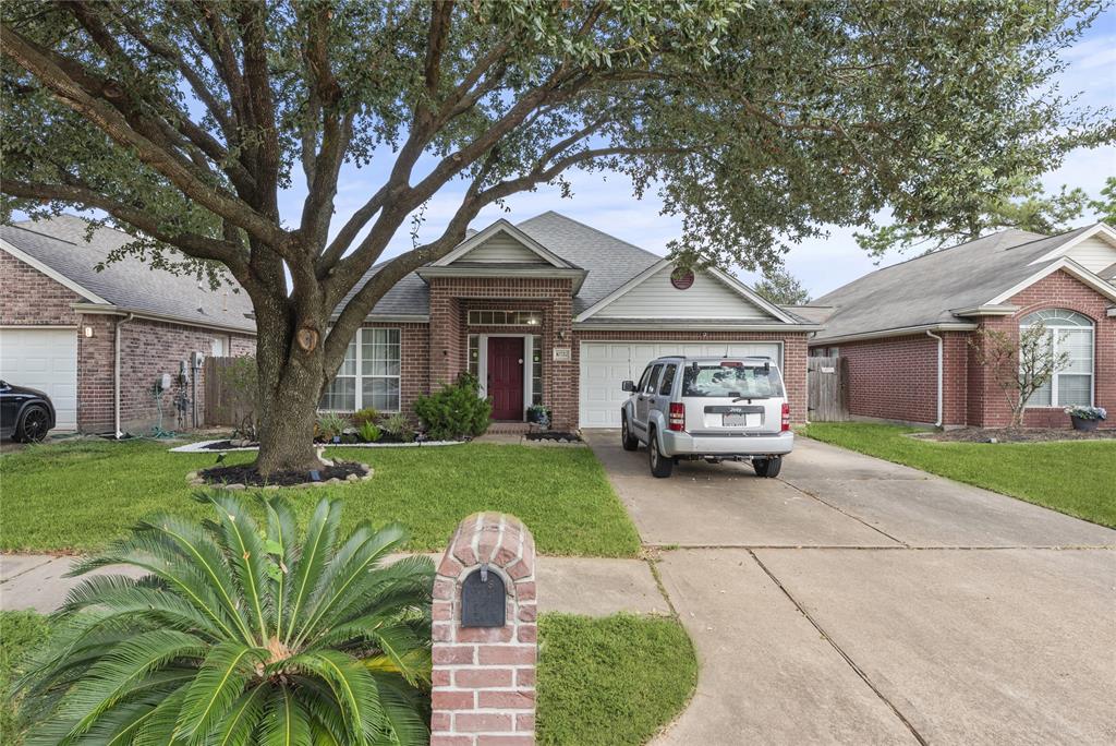 Brick elevation, fresh landscaping and a majestic oak tree offer lovely curb appeal.