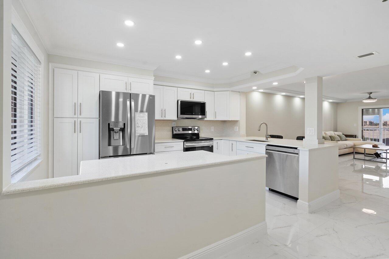 a view of a kitchen with a sink and a refrigerator