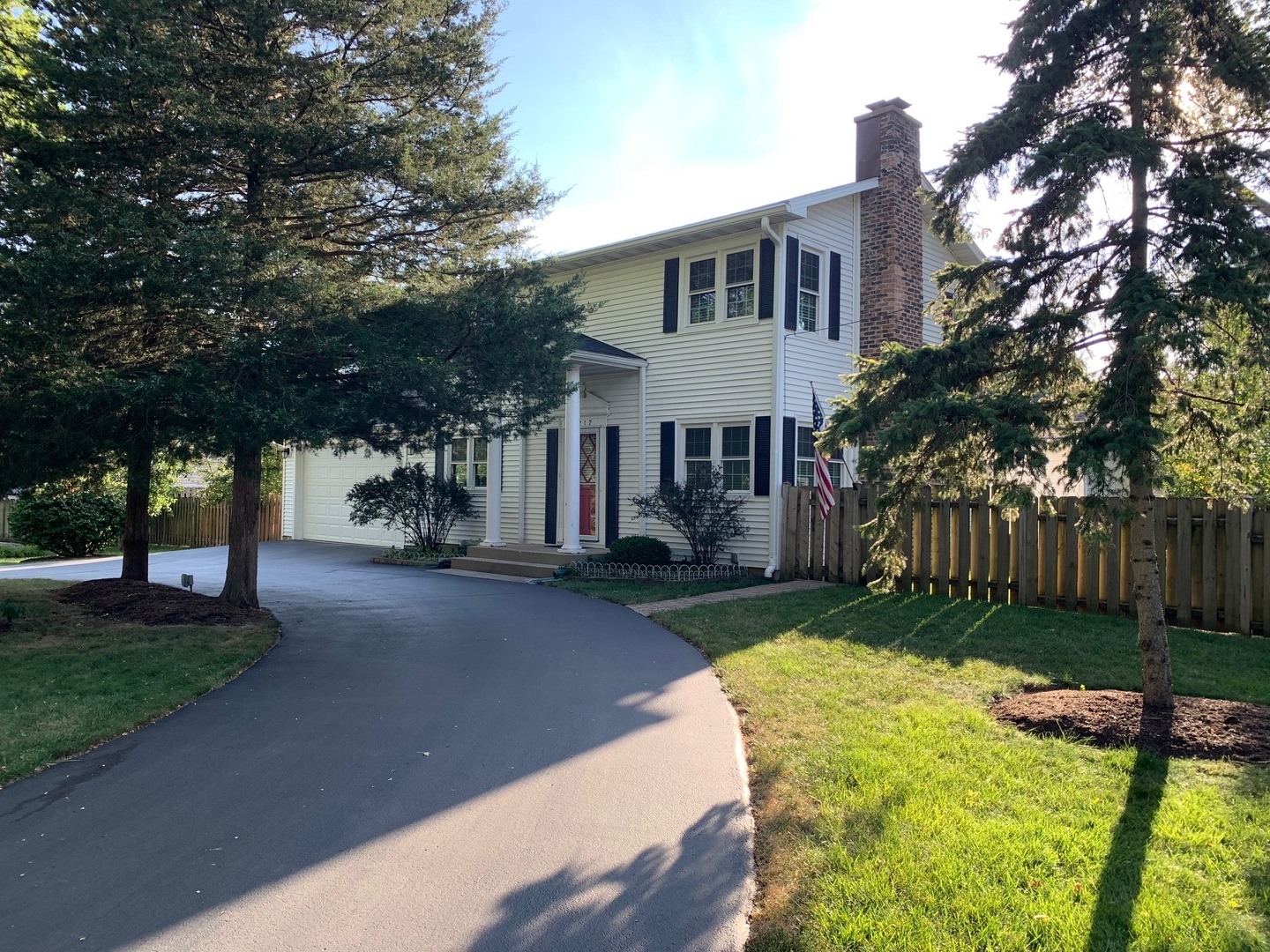 a front view of a house with yard and green space