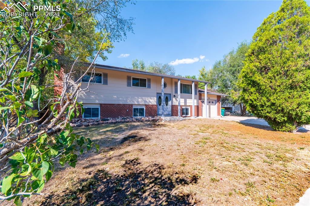 View of front of property with a garage and a front lawn