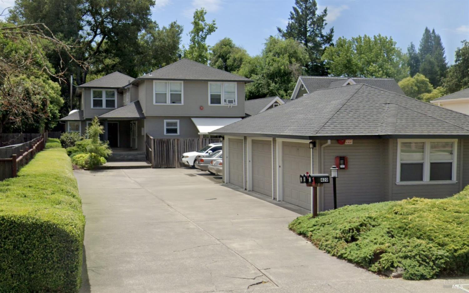 a front view of a house with a yard and potted plants