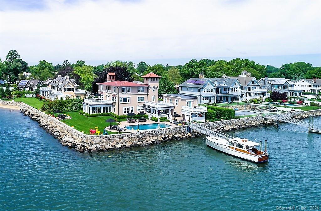 a view of a lake with a house swimming pool and outdoor seating