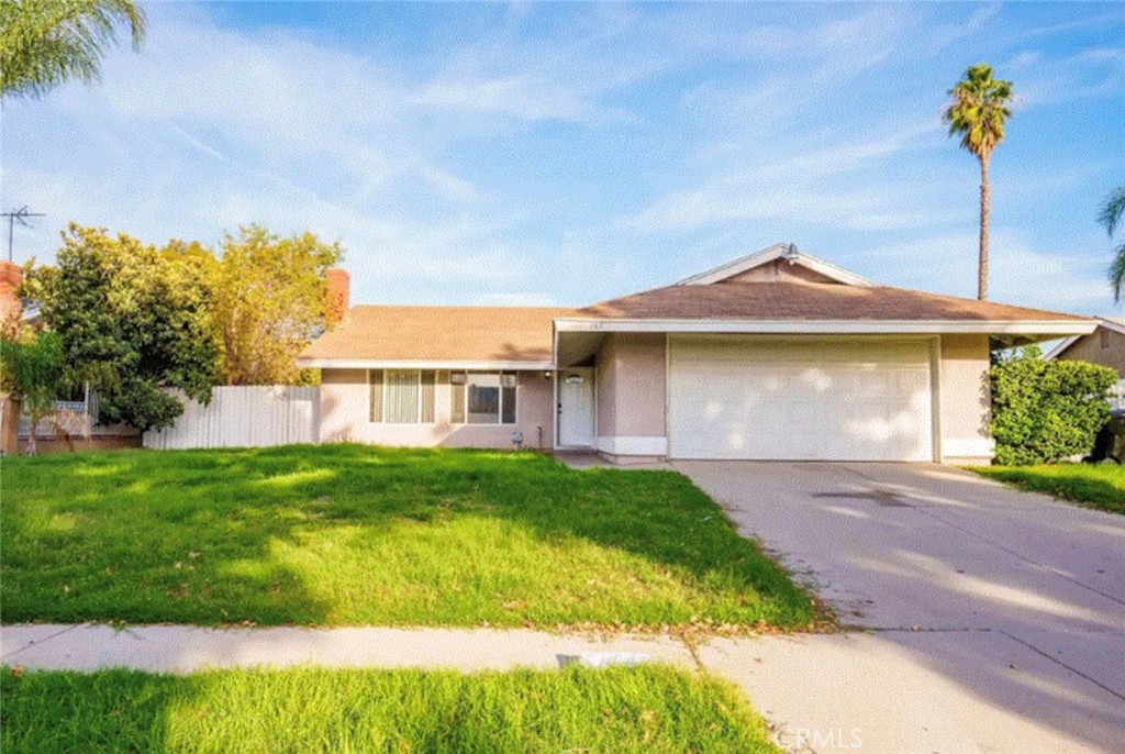 a front view of a house with a garden and yard