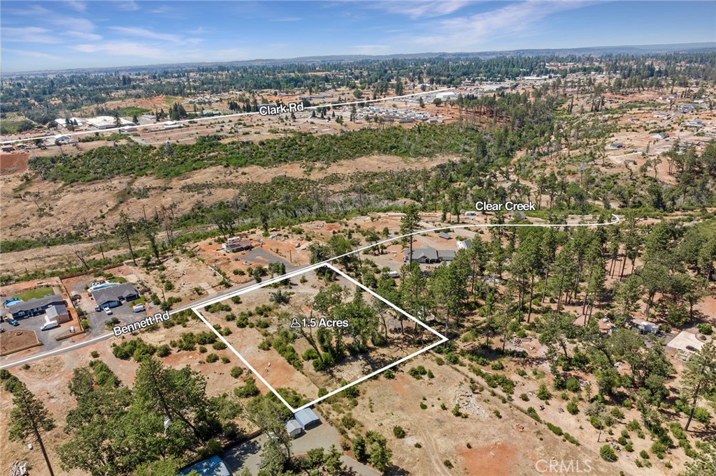 an aerial view of residential houses with outdoor space and trees