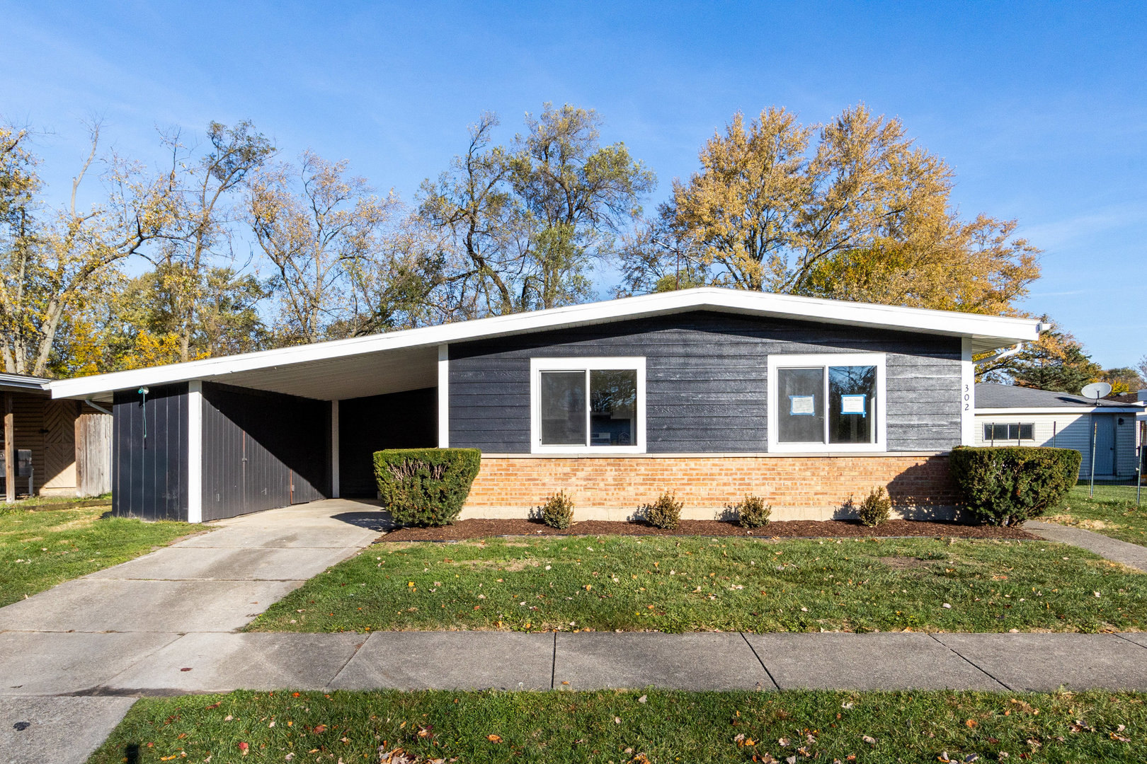 a front view of house with yard and trees in the background