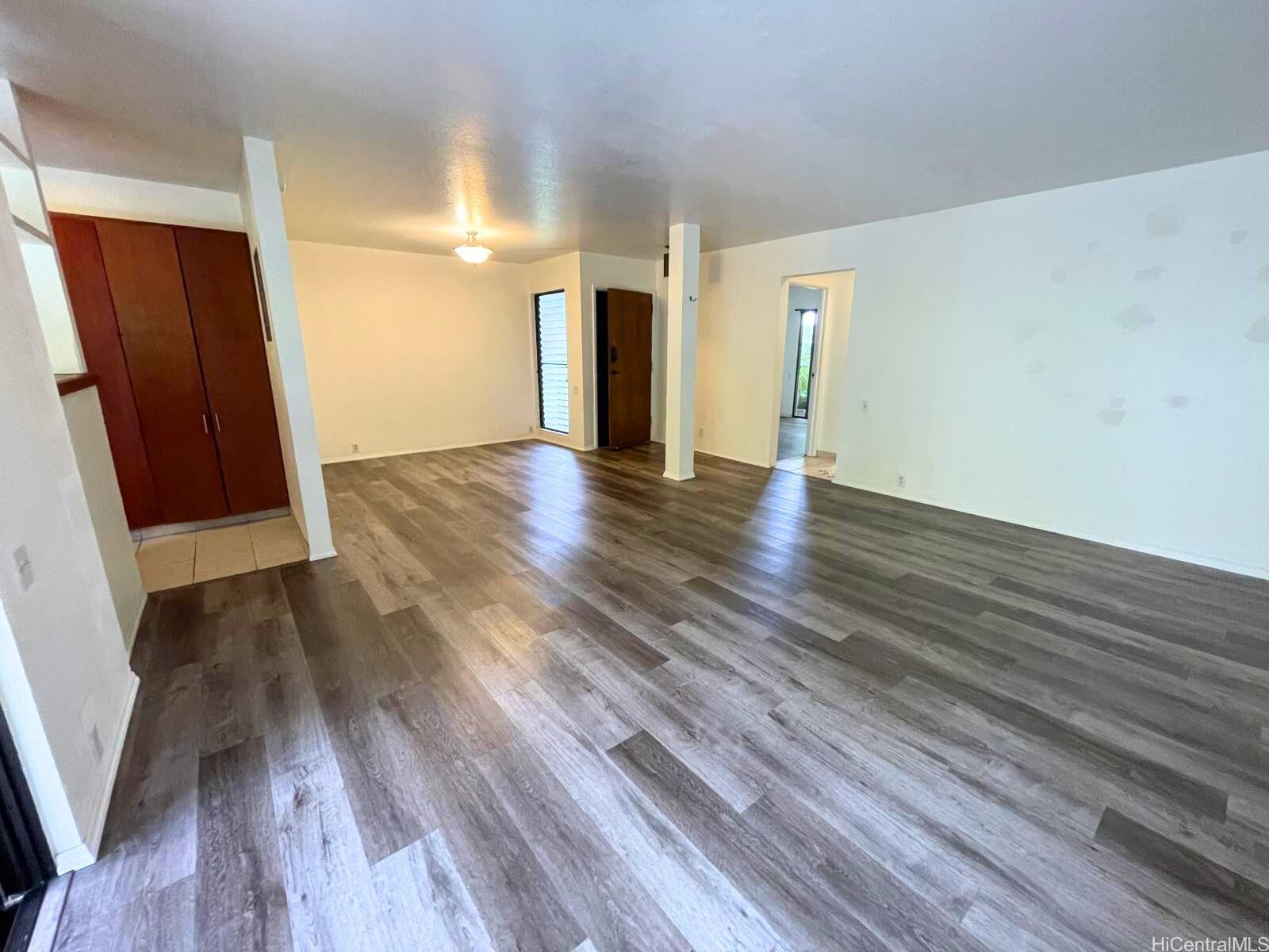 a view of empty room with wooden floor