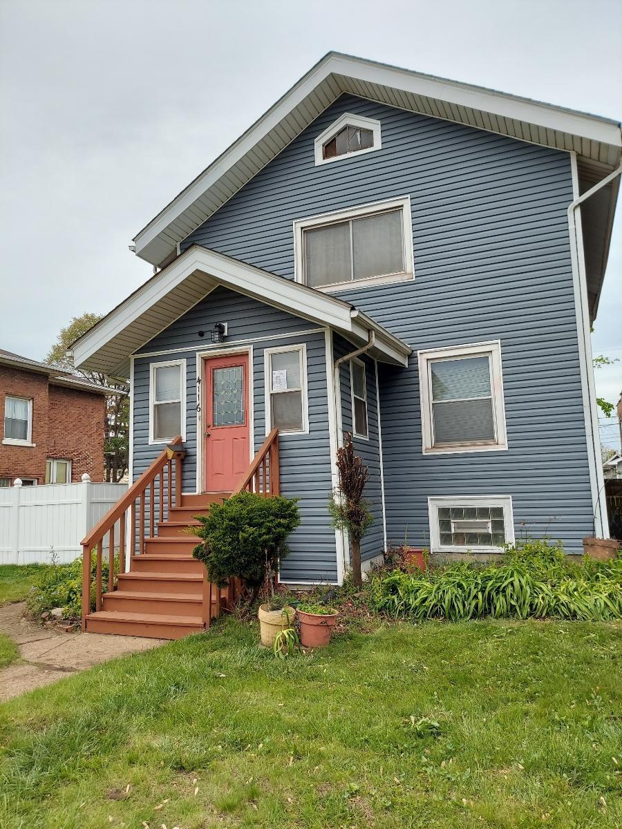 a front view of a house with a yard and trees