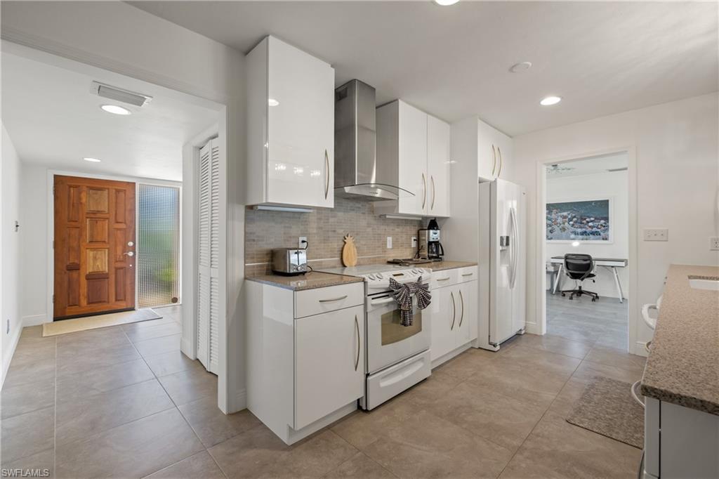 a kitchen with white cabinets and appliances