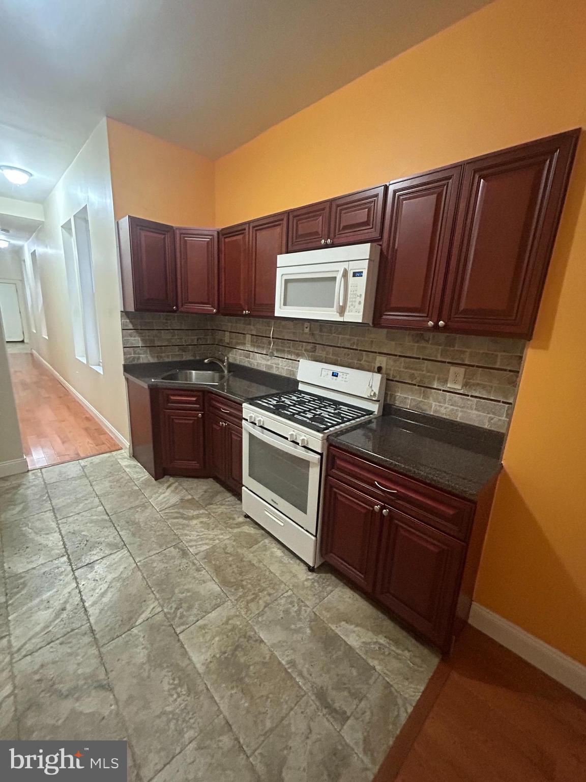 a kitchen with stainless steel appliances granite countertop a stove a sink and a microwave