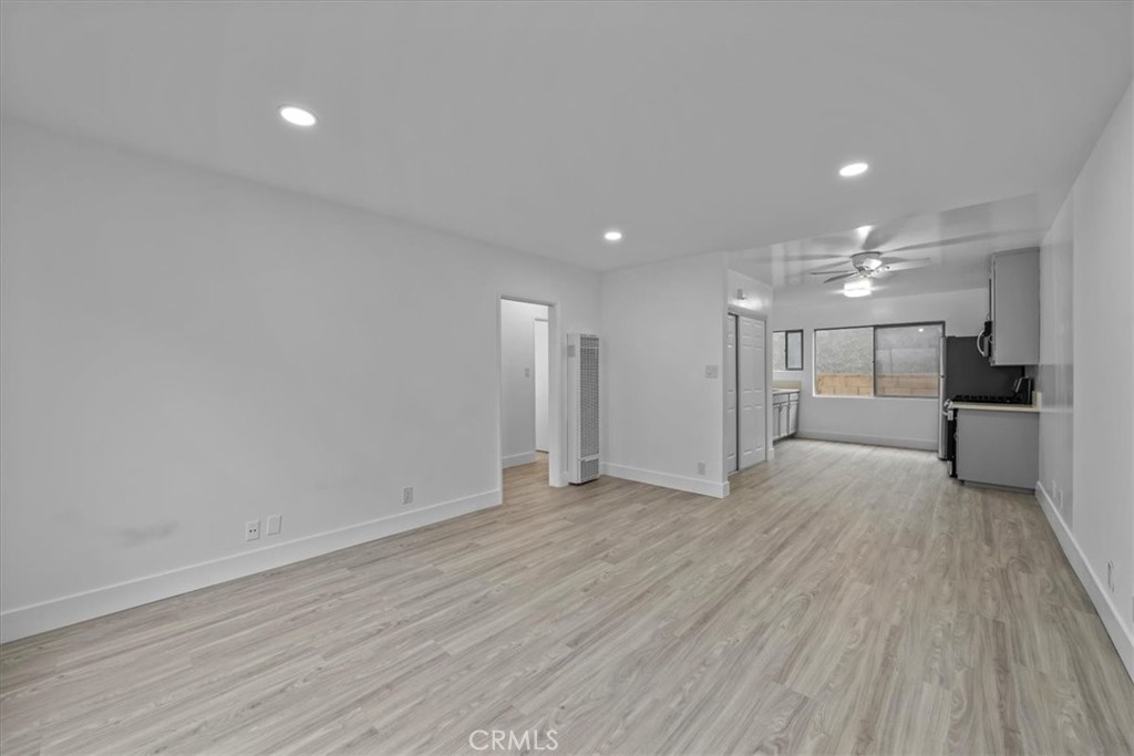 a view of a big room with wooden floor and windows