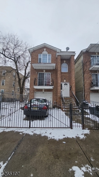 a view of a brick house with large windows and a yard