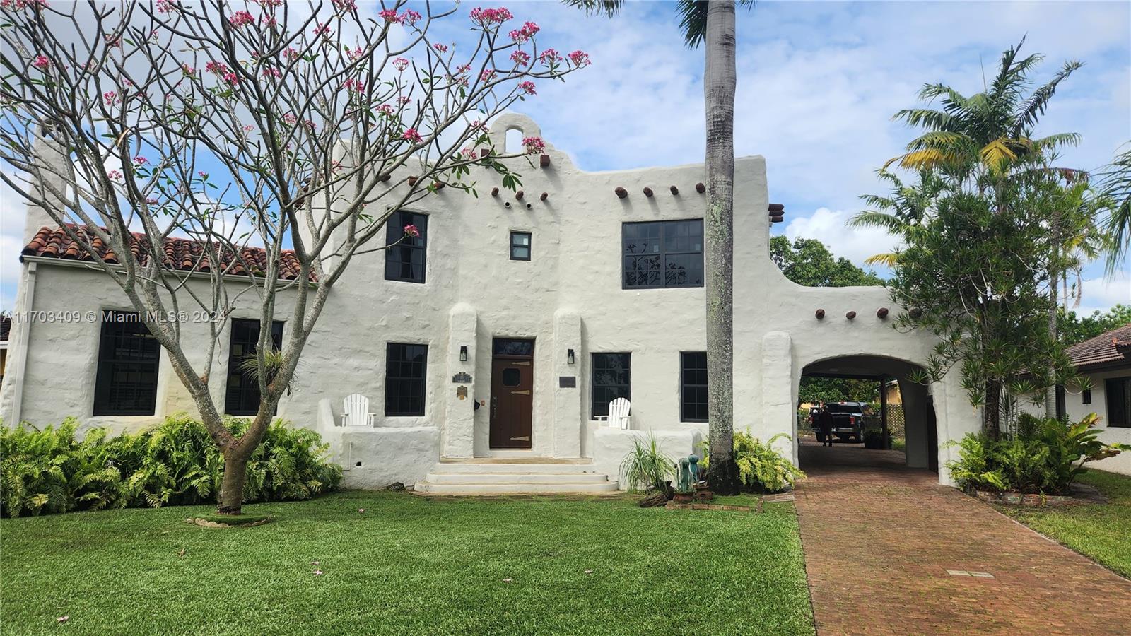 a front view of a house with a garden