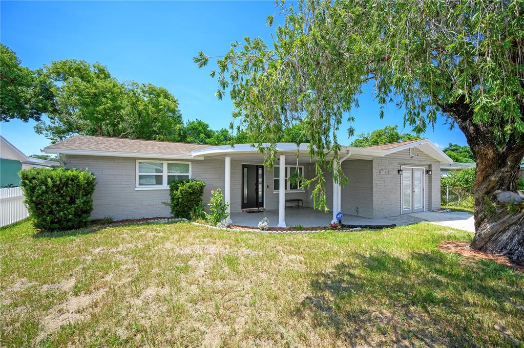 a view of a house with a yard and tree