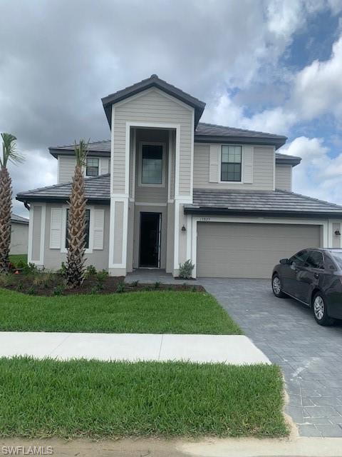 a front view of a house with a yard and garage